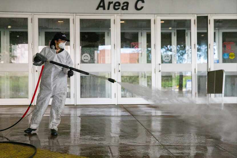 A worker power washes the entrance to Area C at the Kay Bailey Hutchison Convention Center...