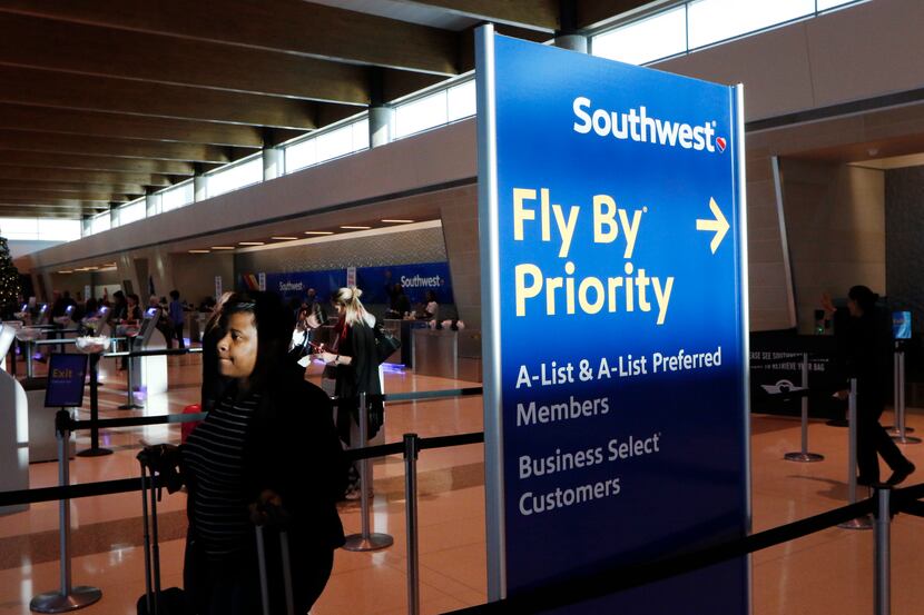 Southwest Airlines passengers checks-in using a kiosk, background, at Dallas Love Field in...