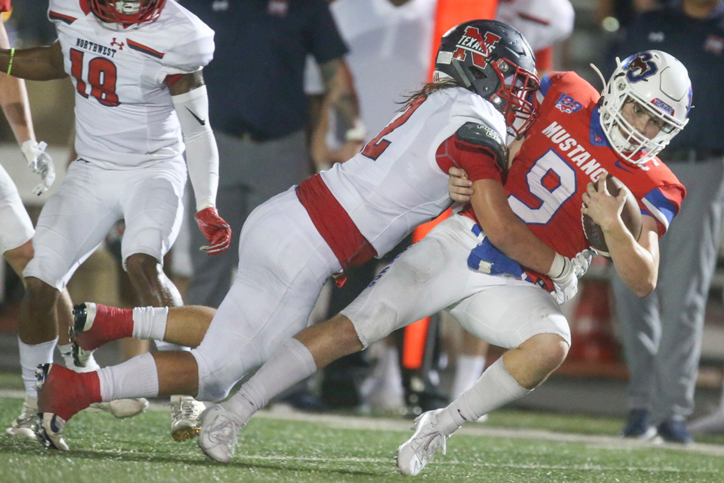 Grapevine quarterback Austin Alexander (9) is brought down by Northwest wide receiver Zavion...