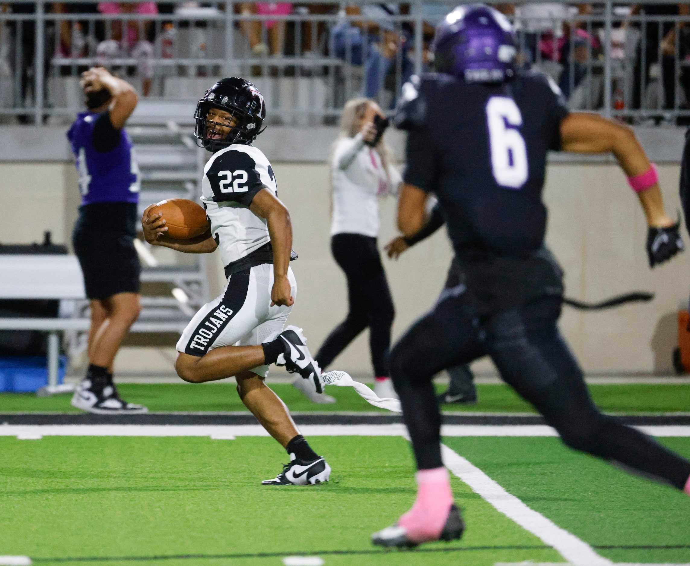 Trinity High’s JT Harris (22) looks back as he completes a run for a touchdown against...