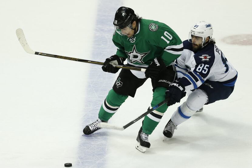 Dallas Stars left wing Patrick Sharp (10) fights for the puck against Winnipeg Jets center...