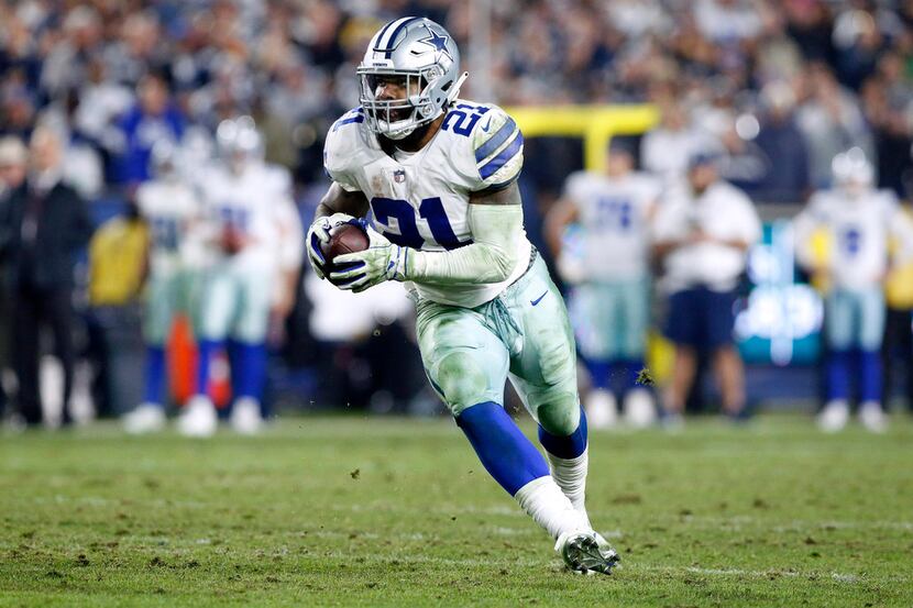 Dallas Cowboys running back Ezekiel Elliott (21) carries the ball after quarterback Dak...