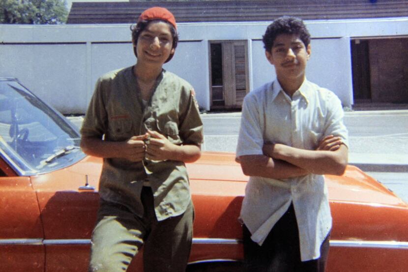 David Rodriguez, 13, left, and his brother Santos Rodriguez, 12, stand by a relative's car...
