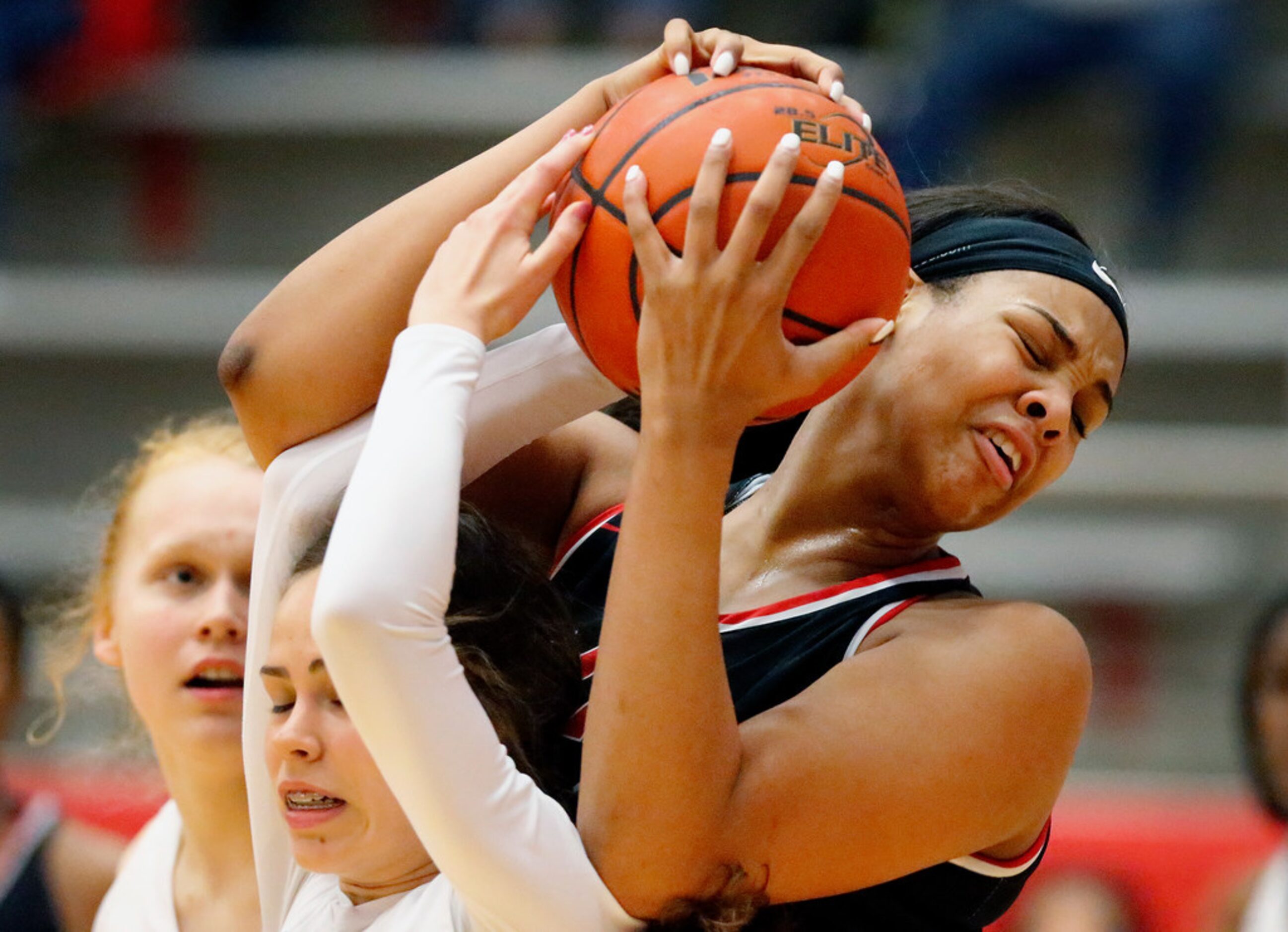 Irving MacArthur High School center Hannah Gusters (21) tries to wrestle the ball from...