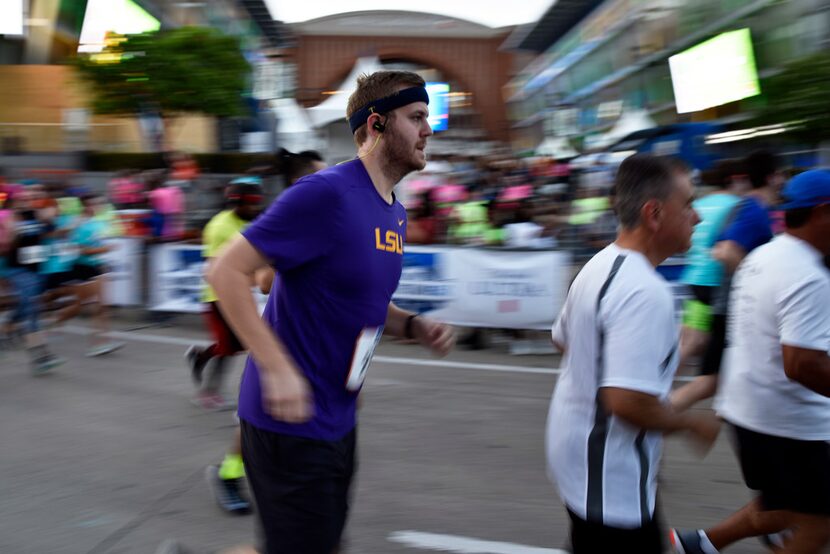 Runners leave the starting line to kick-off the 2018 Mavs Run This Town 5k outside of the...