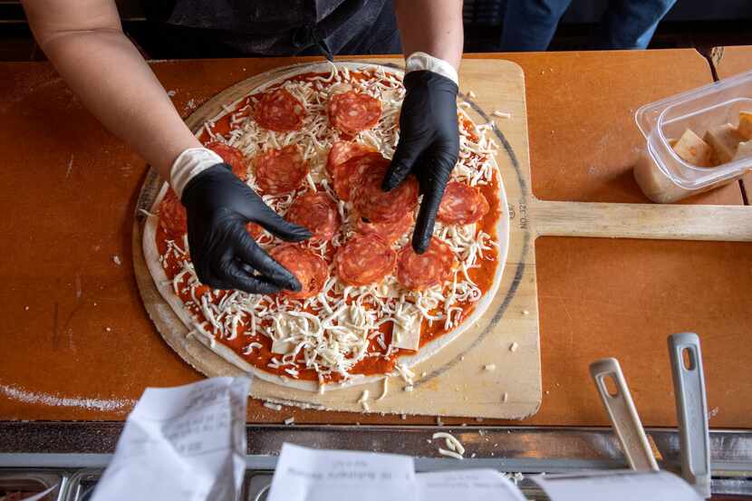 A pizza is made at Greenville Avenue Pizza Company on March 19, 2020, in Dallas.