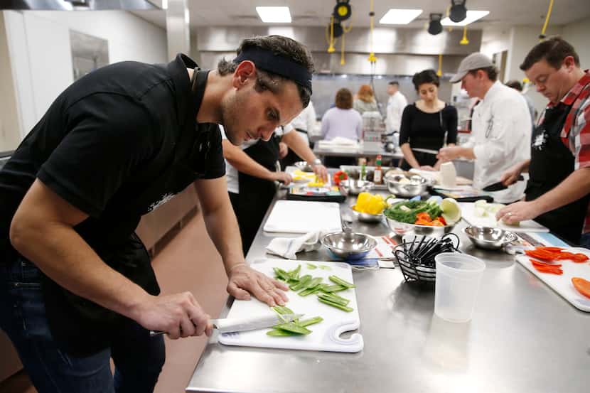 Ayman Kasseba of Dallas works on cutting jalapeños for a ceviche dish during a cooking class...