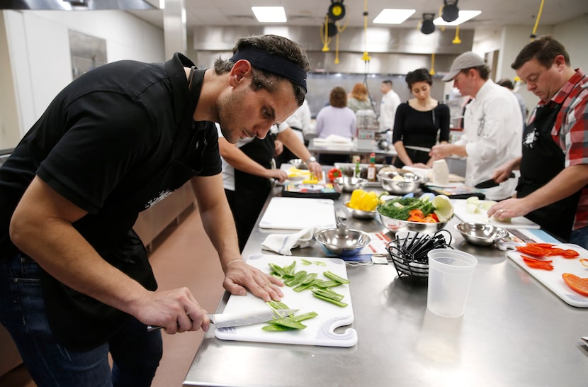 Ayman Kasseba of Dallas works on cutting jalapeños for a ceviche dish during a cooking...