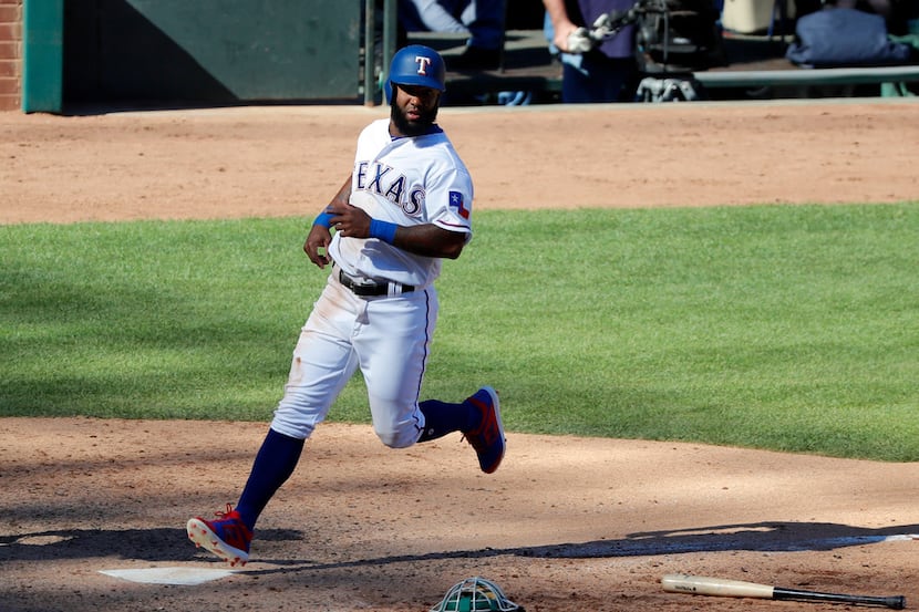 Texas Rangers' Danny Santana crosses home plate on a single by Delino DeShields in the...