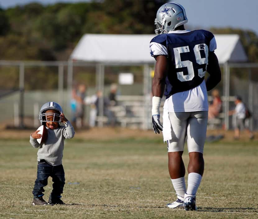 Ernie Sims IV plays with his father Dallas Cowboys inside linebacker Ernie Sims (59) during...