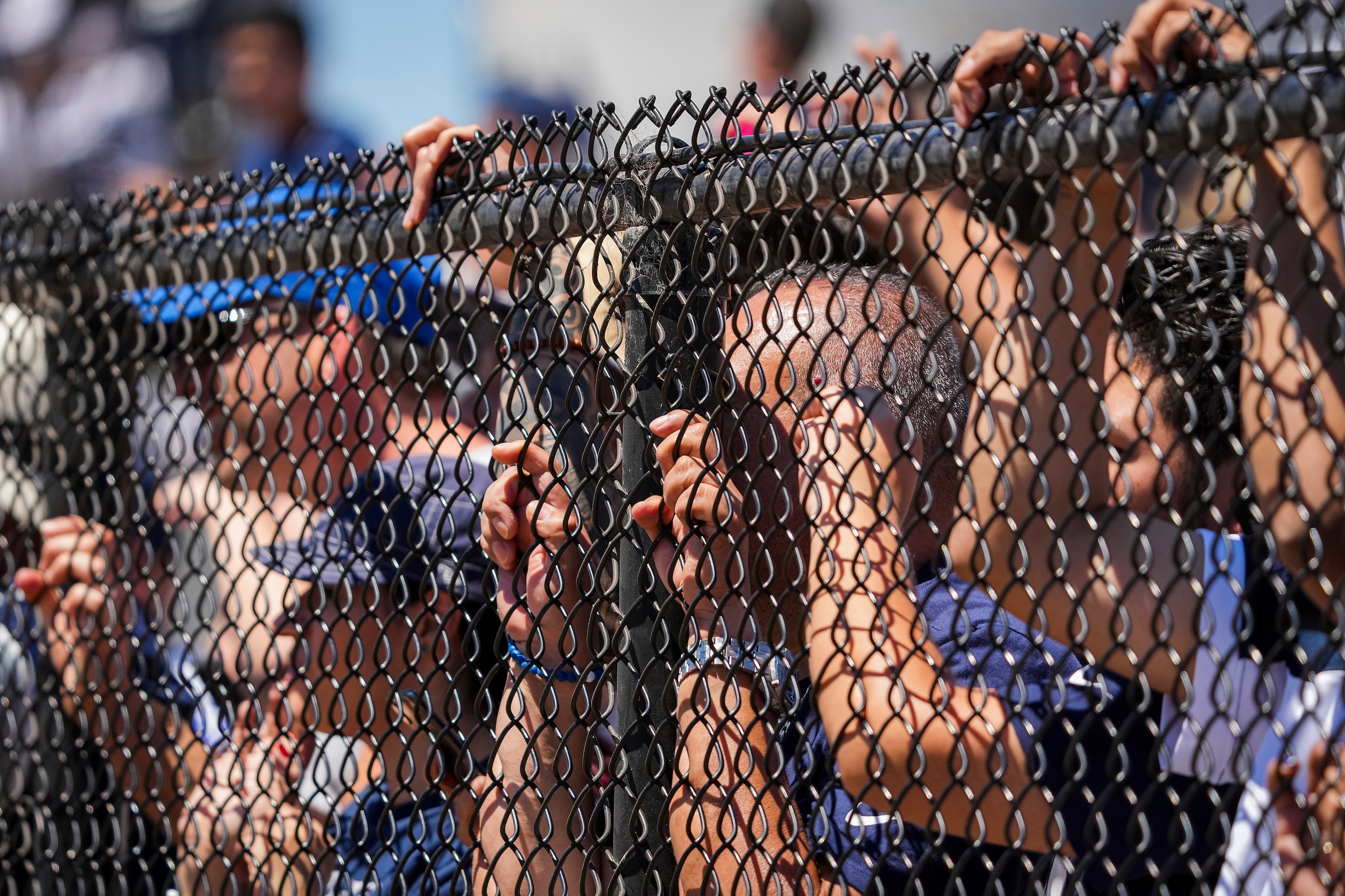 Fans press against a fence to watch the Dallas Cowboys practice at training camp on Sunday,...