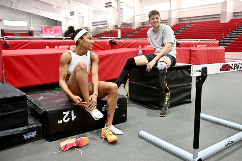 FILE - Olympic long jumper Tara Davis-Woodhall, left, talks with her husband, Paralympian...