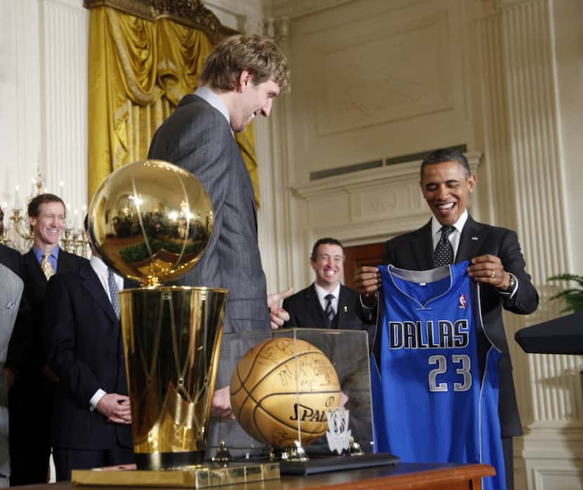 President Barack Obama is presented with a Dallas Mavericks team basketball jersey from Dirk...