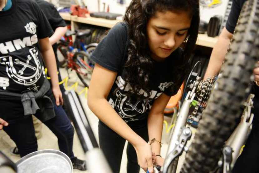 
Eighth-grader Lezly Padilla fixes the gears on a bicycle during Garland ISD's after-school...