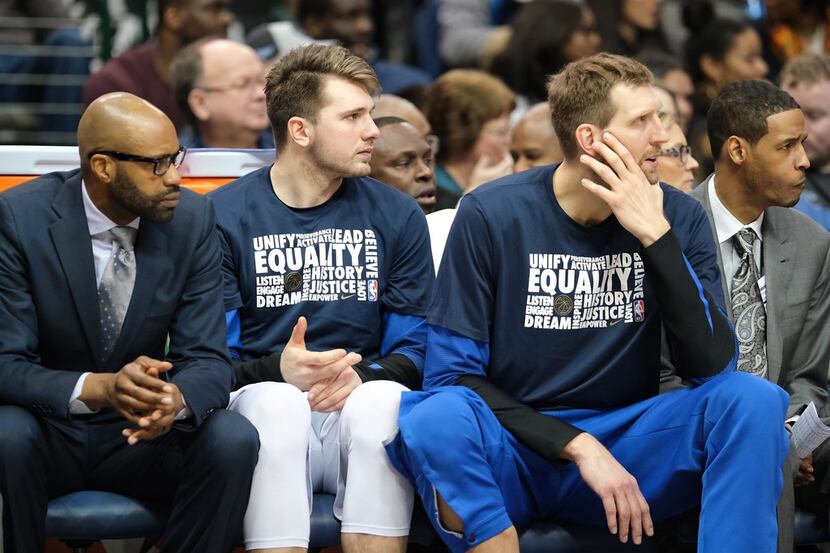 Dallas Mavericks forward Luka Doncic and forward Dirk Nowitzki watch from the bench during...