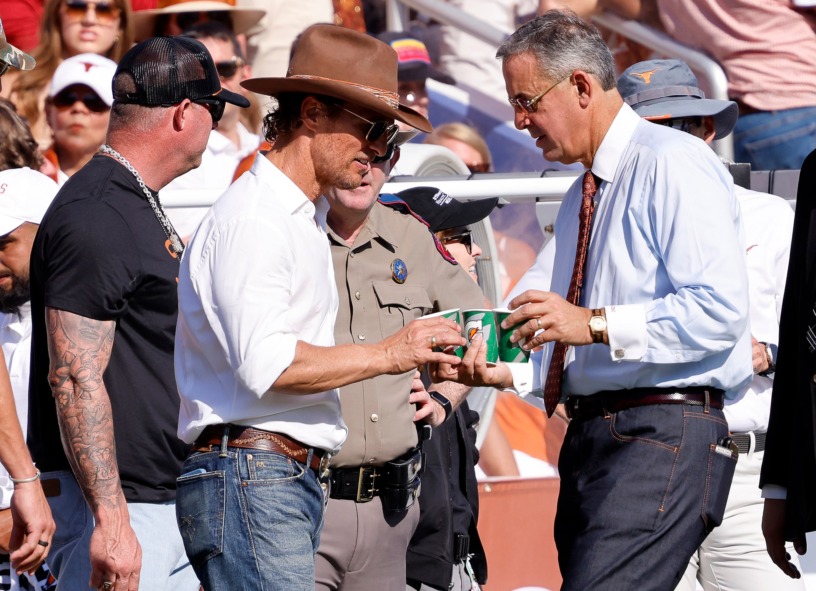 Texas Longhorns Athletic Director Chris Del Conte (right) brings drinks on the sidelines to...