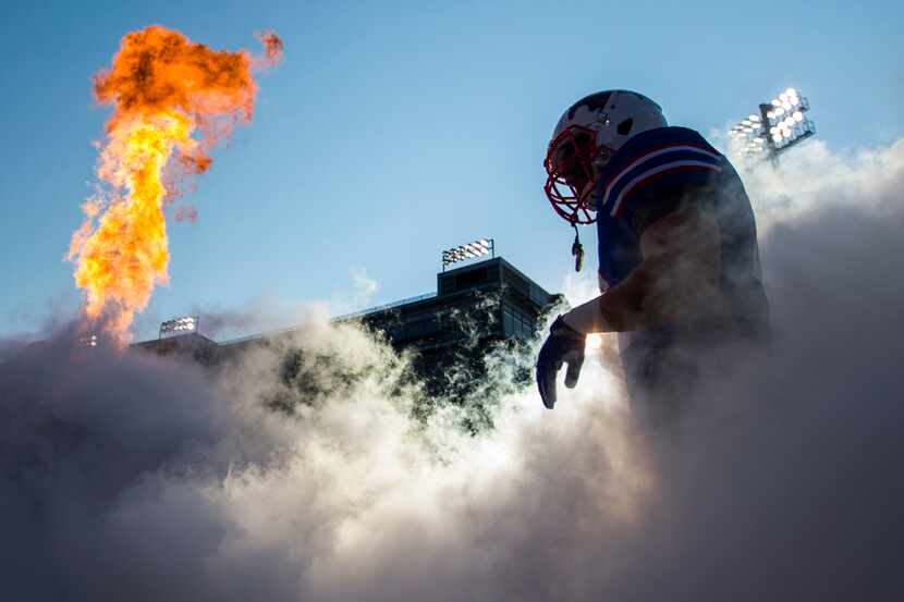 Southern Methodist Mustangs players enter the stadium before a football game between UNT and...
