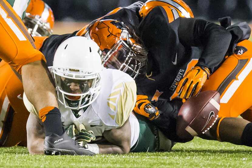 Baylor running back Shock Linwood (32) loses a fumble as he is brought down by the Oklahoma...