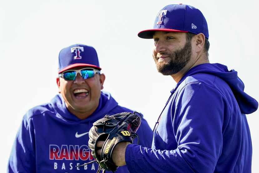 El coach de pitcheo de los Texas Rangers, Julio Rangel, sonría mientras observa el trabajo...