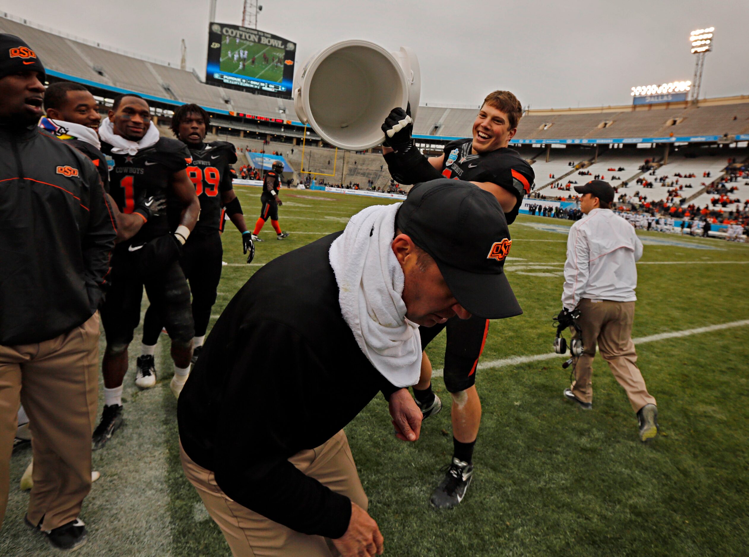 Oklahoma State Cowboys defensive end Cooper Bassett (80) pretends to dump a bucket of water...