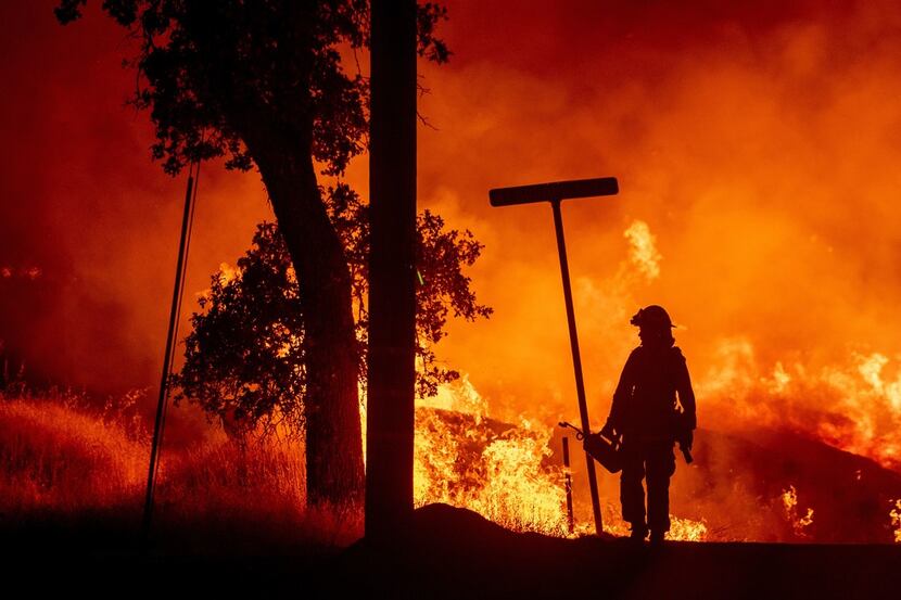 A firefighter lights backfires during the Carr fire in Redding, Calif.,on Friday. One person...