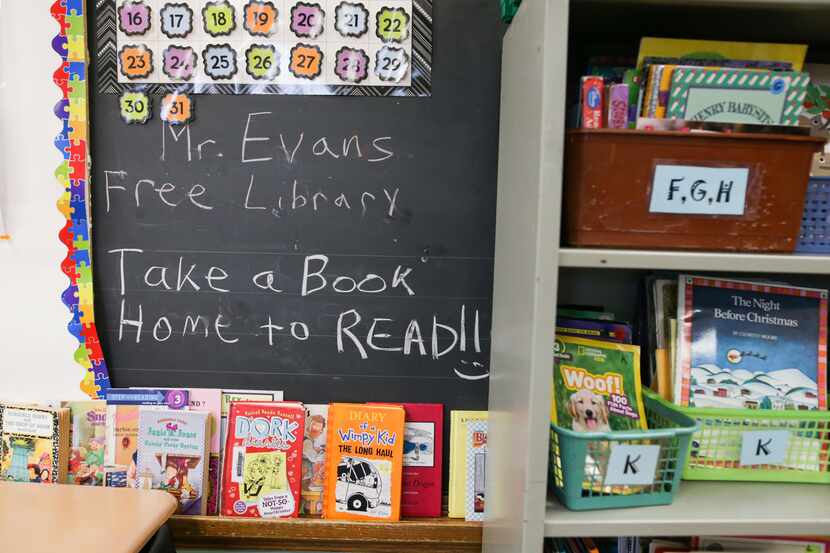 Books are displayed on a free library shelf inside the classroom of Richard Evans, a teacher...