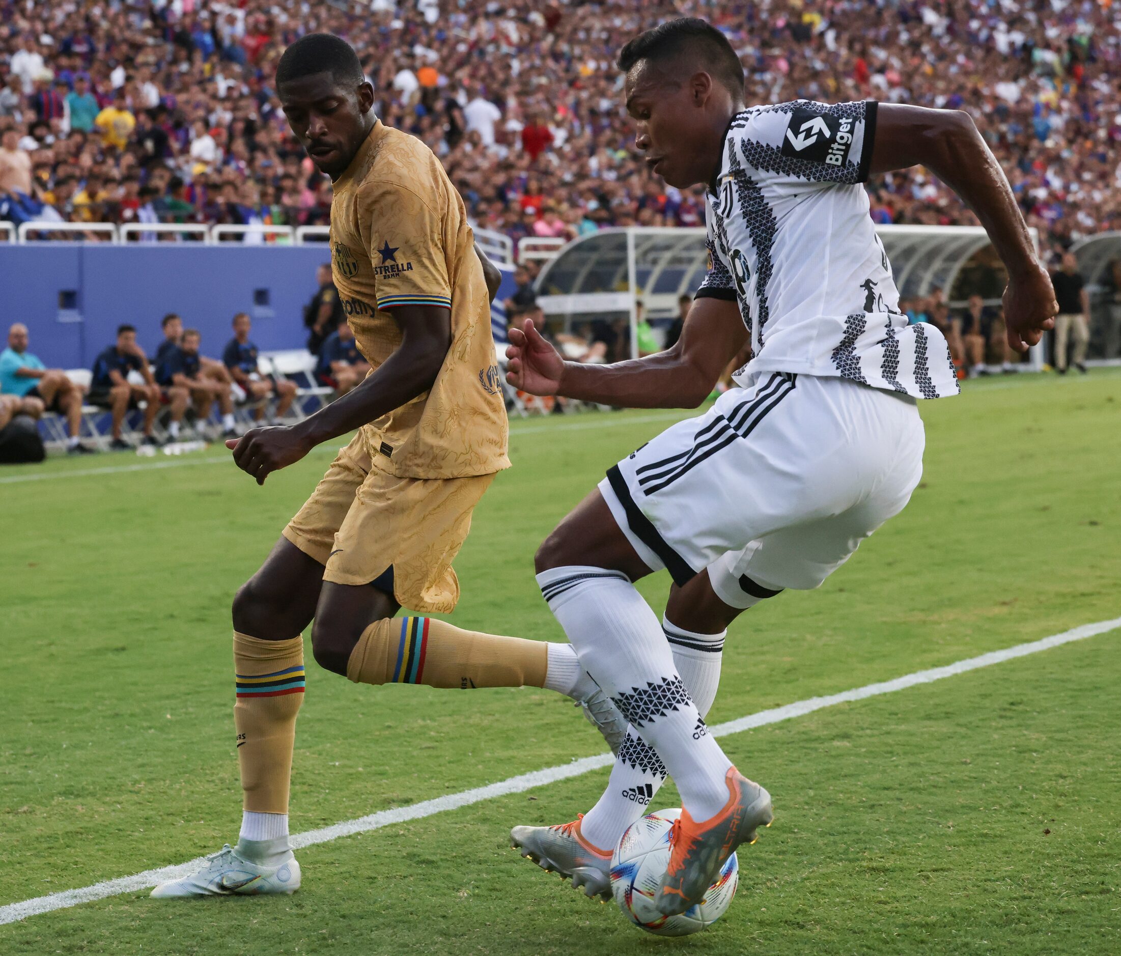 Barcelona forward Ousmane Dembélé (7) runs past Juventus defender Alex Sandro (12) as he...