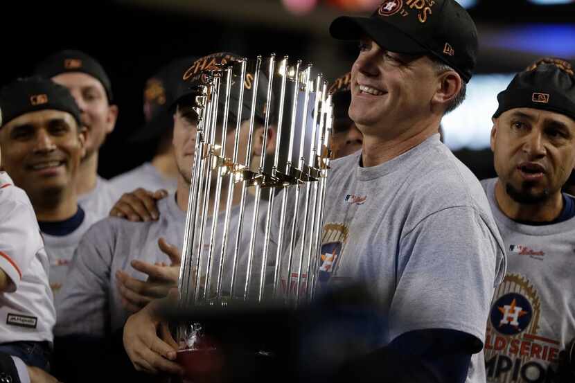 Houston Astros manager A.J. Hinch holds the championship trophy after Game 7 of baseball's...