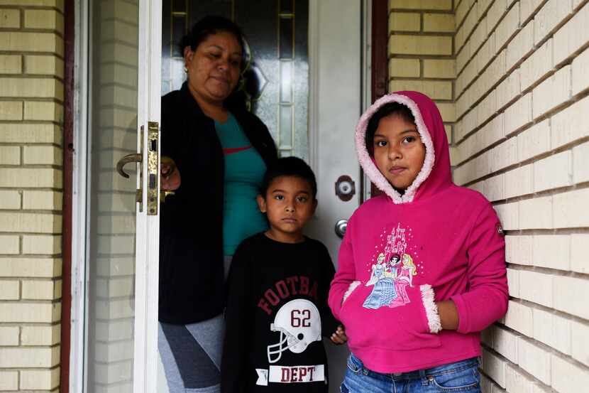 Iris Cañas, junto a sus hijos Gerber y Ximena, en las afueras de su casa en el sureste de...