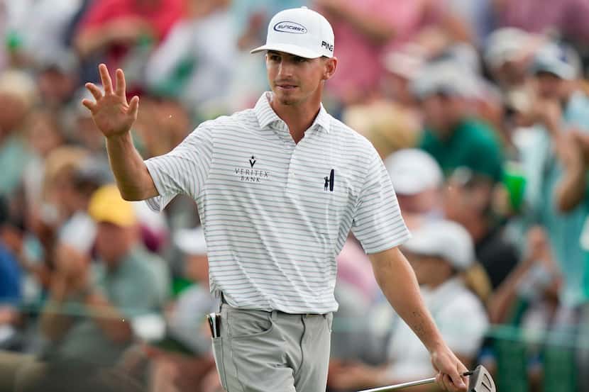 Sam Bennett waves after his putt on the 18th hole during the second round of the Masters...