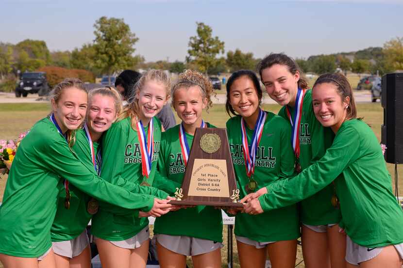 The Southlake Carroll girls cross country team celebrates winning the District 5-6A meet...