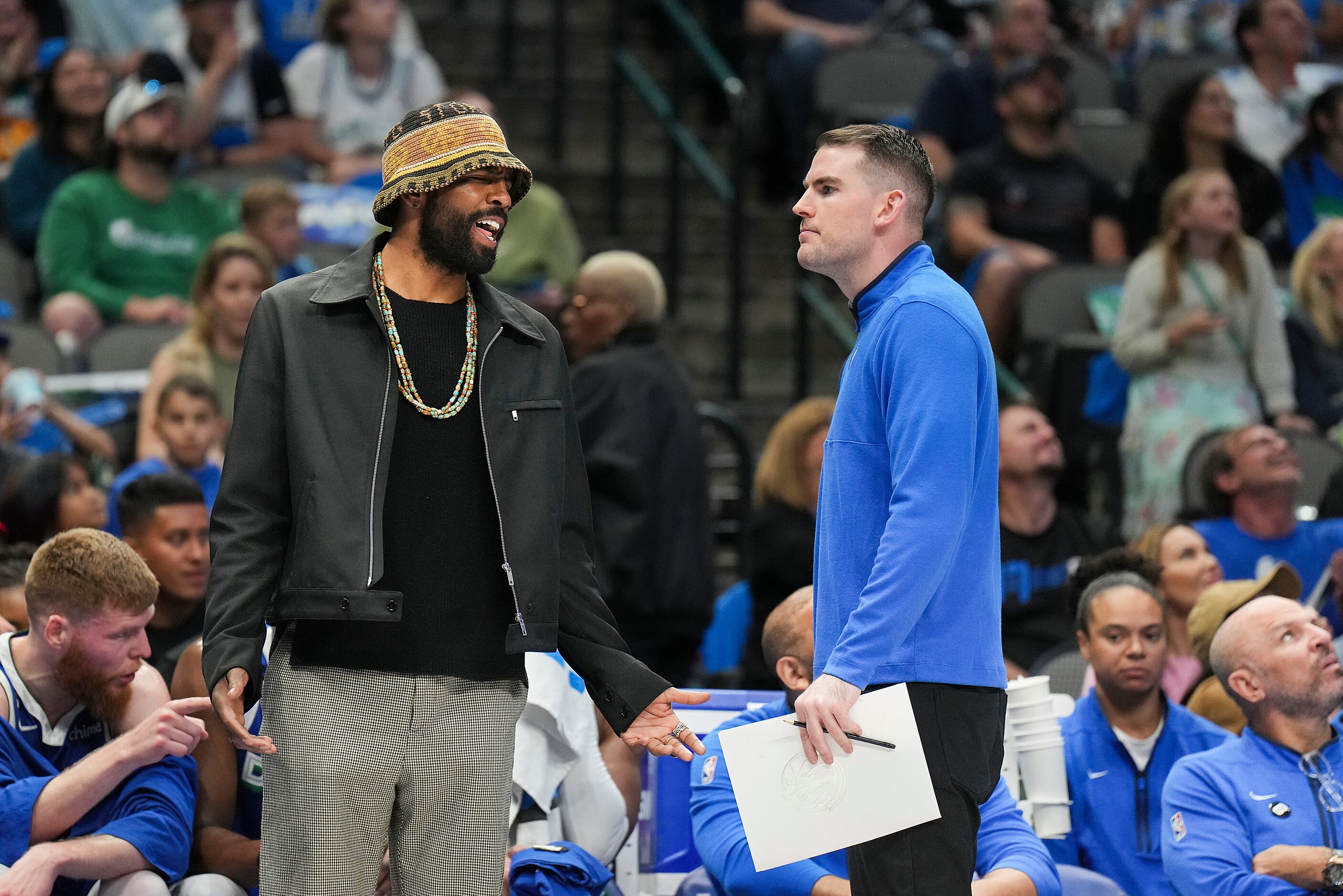 Dallas Mavericks guard Kyrie Irving talks with assistant coach Greg St. Jean during a...