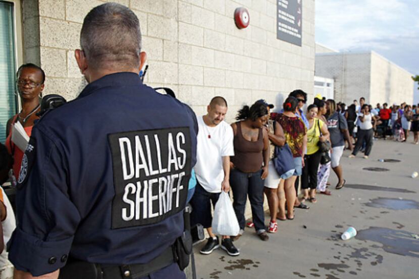 A Dallas County sheriff''s deputy monitors the line for rental assistance voucher...
