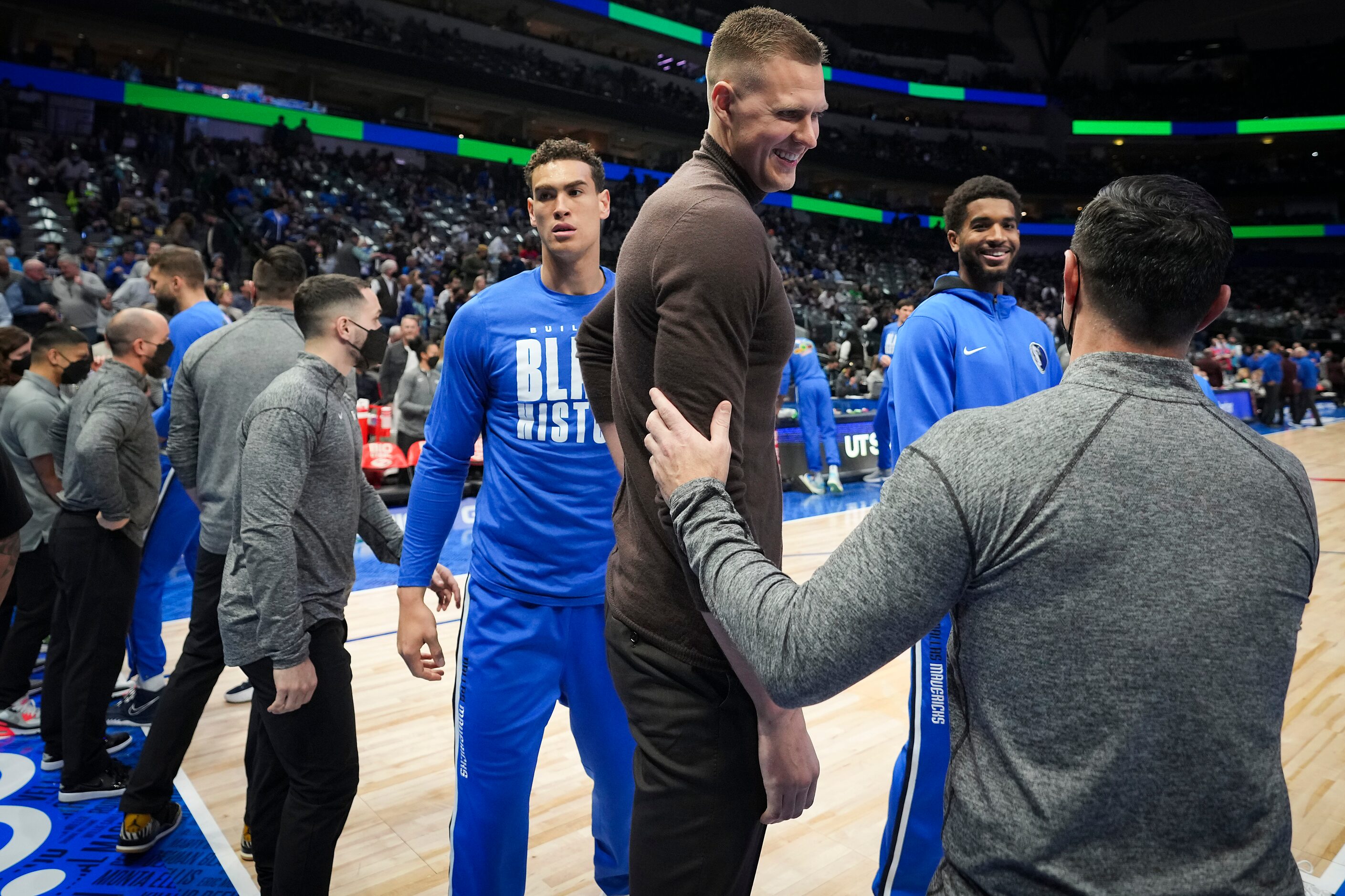 Dallas Mavericks center Kristaps Porzingis watches wearing street clothes before an NBA...