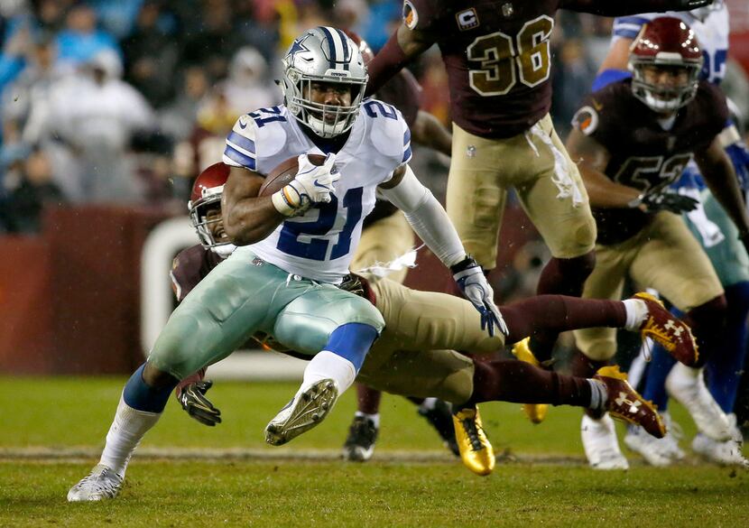 Dallas Cowboys running back Ezekiel Elliott (21) gets away from a tackle by Washington...