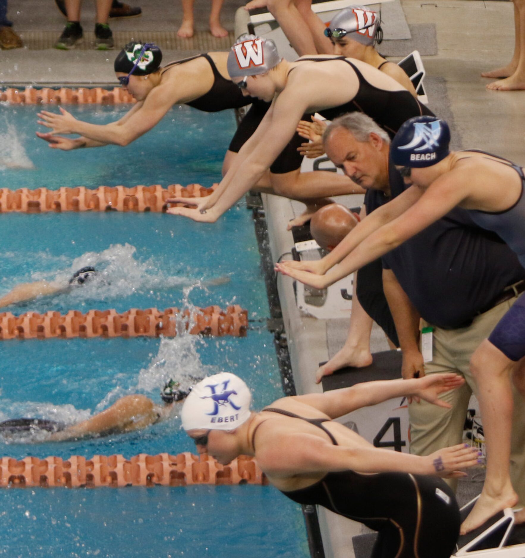 Southlake Carroll's Corbyn Cormack, at top, lunges into the pool on the second leg of her...