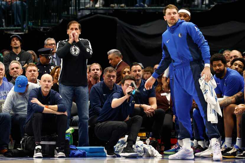 Dallas Mavericks owner Mark Cuban cheers from the sideline during the first half of an NBA...