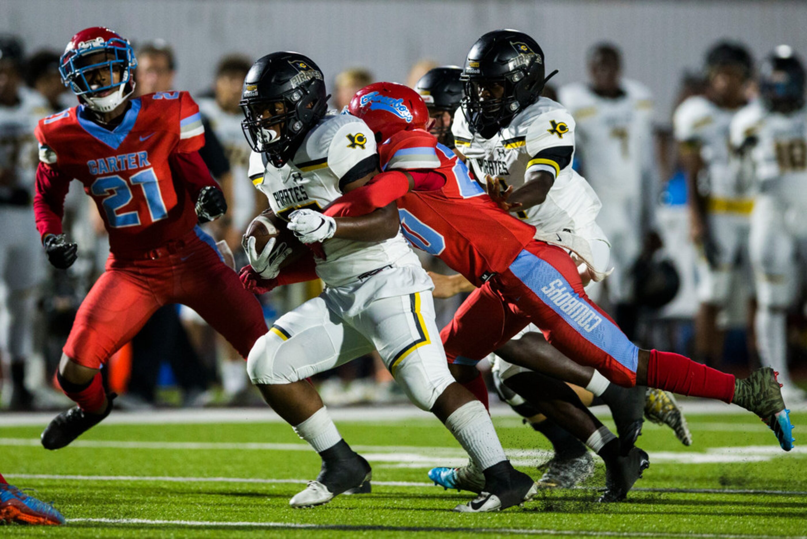 Crandall running back Landon Thomas (20) is tackled by Carter defensive back Jy'Quavion...