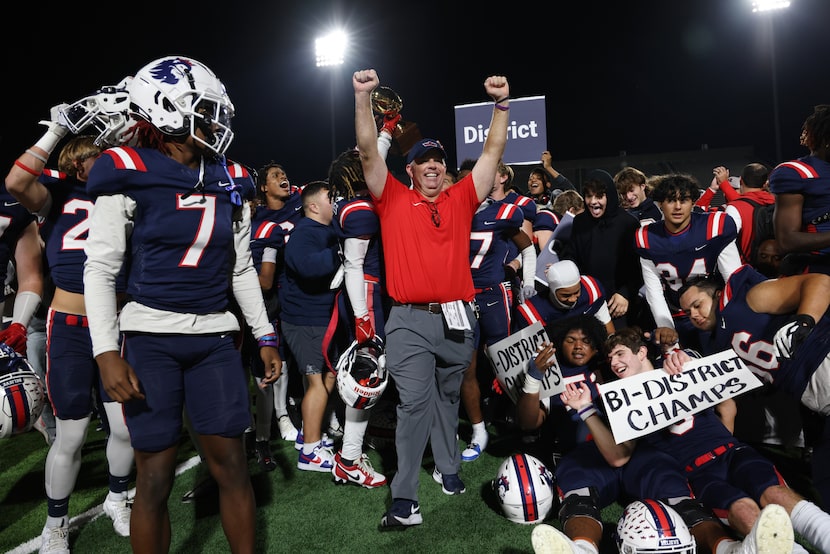 Richland head coach Ged Kates, center, celebrates with his players at midfield after they...