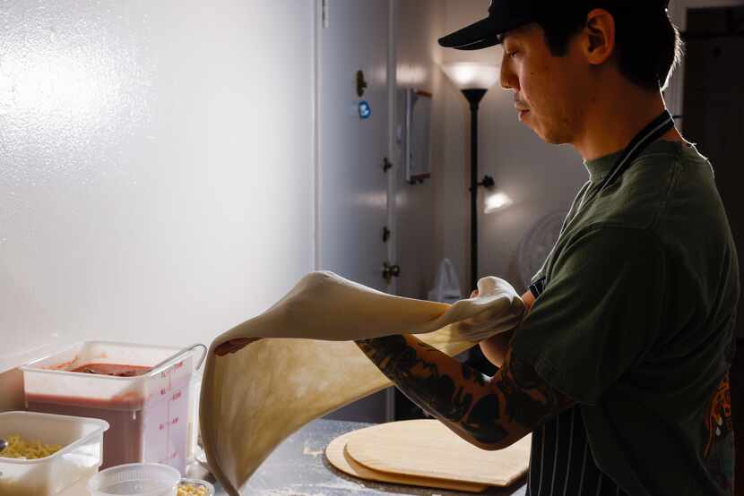 Peter Cho prepares the dough for a cheese pizza.