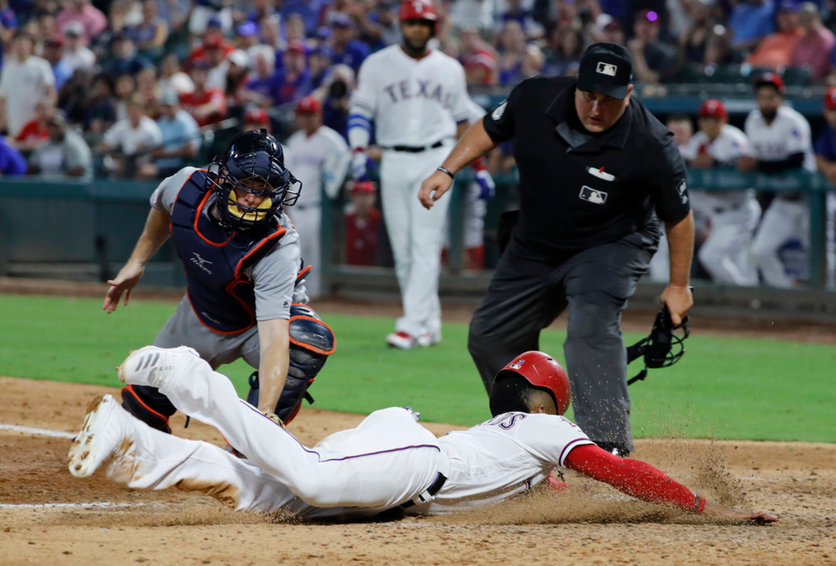 Texas Rangers' Delino DeShields, front, reaches the plate safely under the attempted tag by...