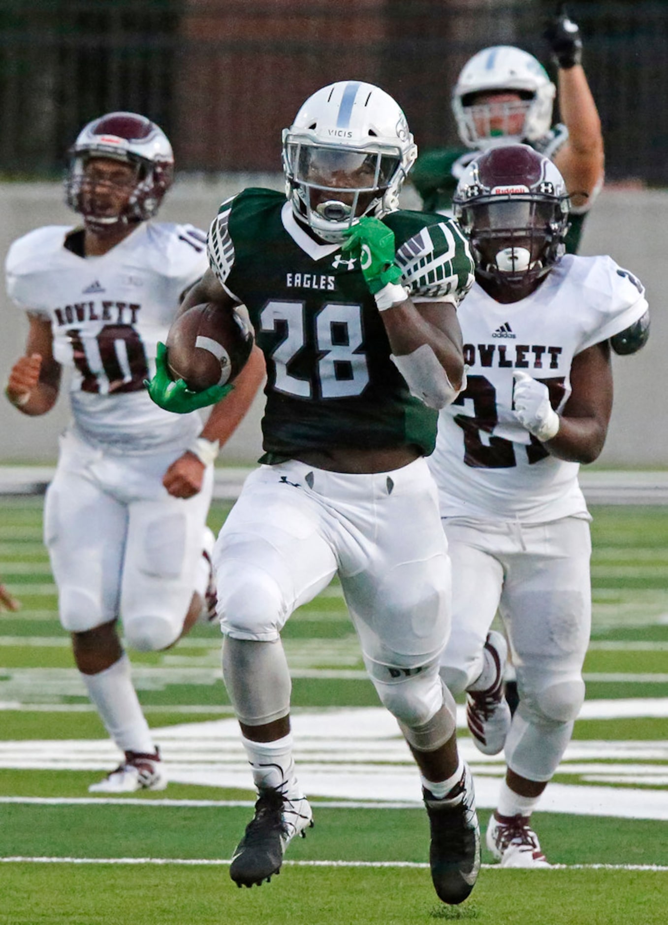 Prosper High School running back JT Lane (28) outruns Rowlett High School defensive backs...