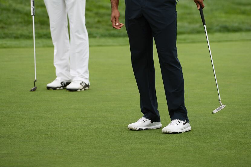 LA JOLLA, CA - JANUARY 24: Tiger Woods assesses a putt as Jordan Spieth looks on during the...