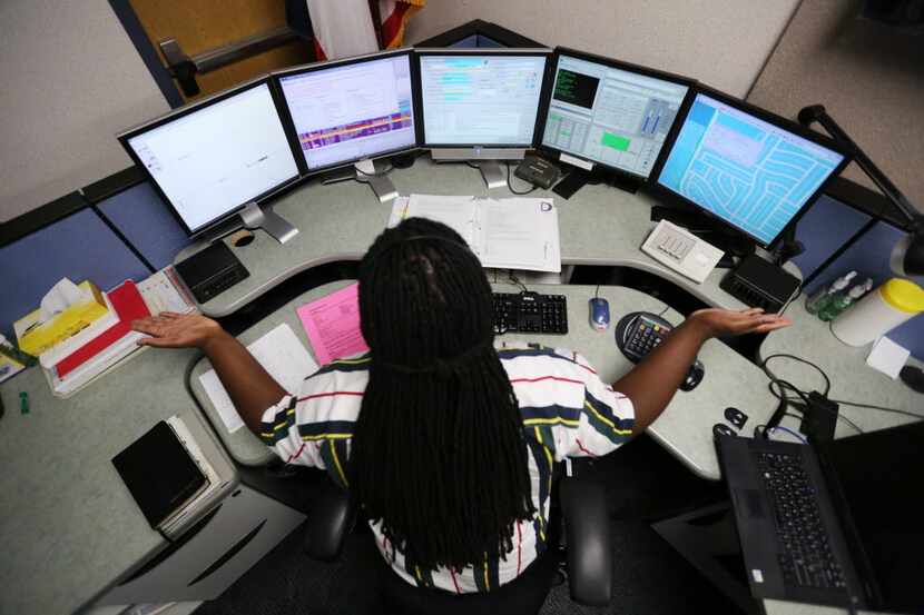 Ward Hughes of Irving talks to a 911 caller inside the dispatch center on the lower level in...
