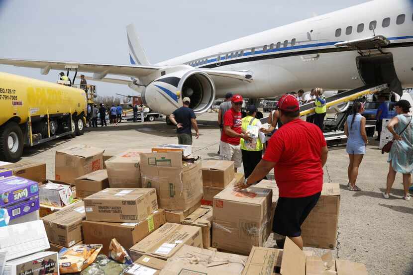 Hurricane relief supplies are unloaded from the Dallas Mavericks' plane in San Juan, Puerto...