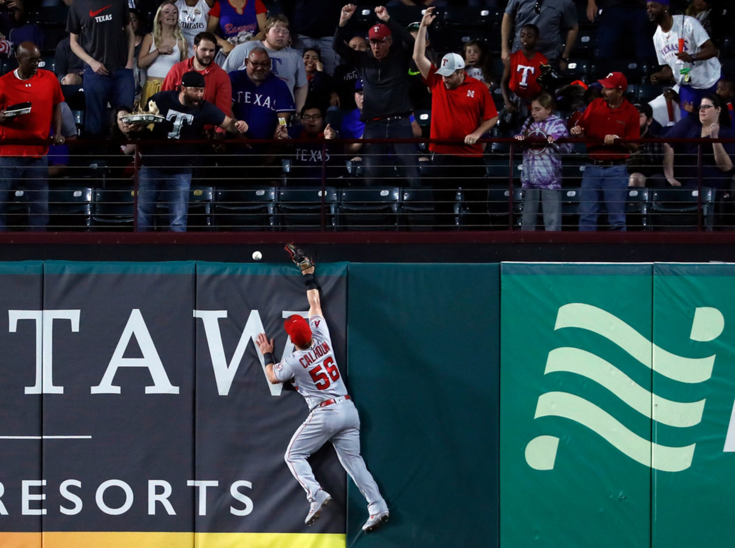 Fans look on as a ball that bounced off the top of Los Angeles Angels right fielder Kole...