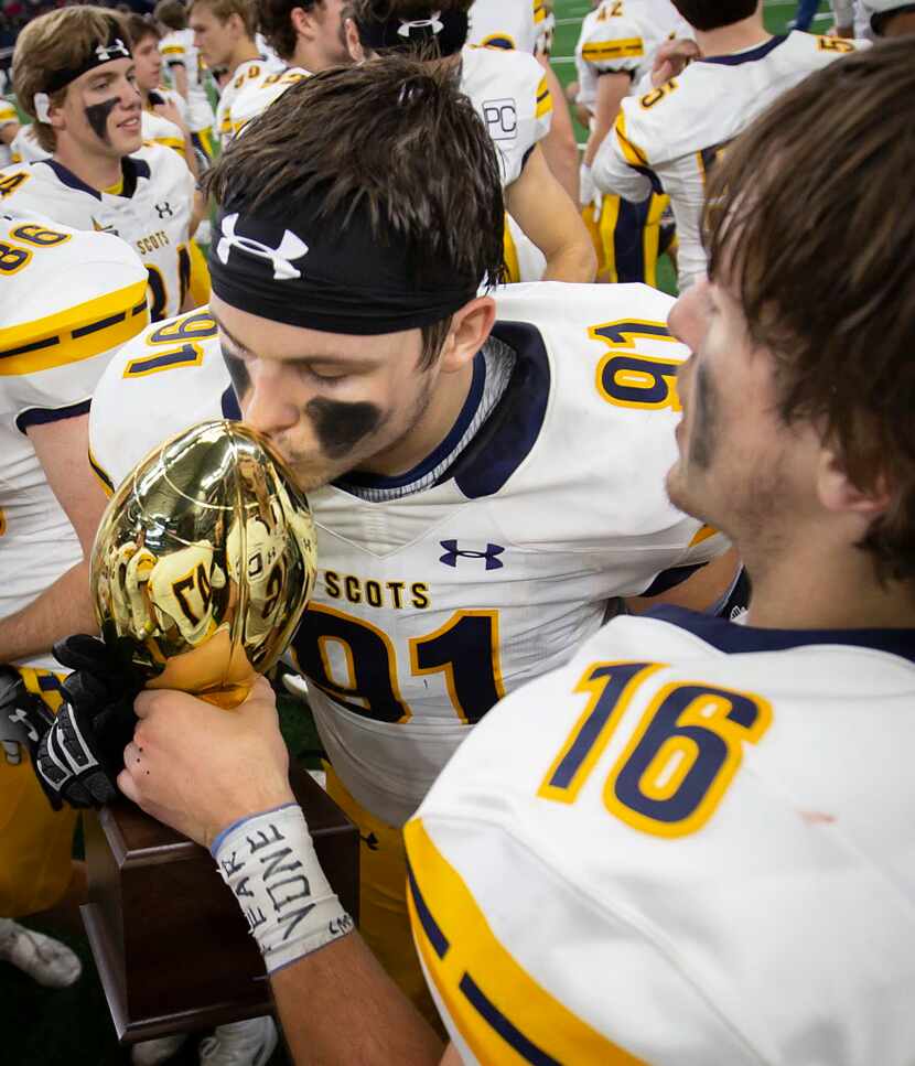 Highland Park defensive lineman Jeremy Hanes (91) kisses the game trophy which is held by...