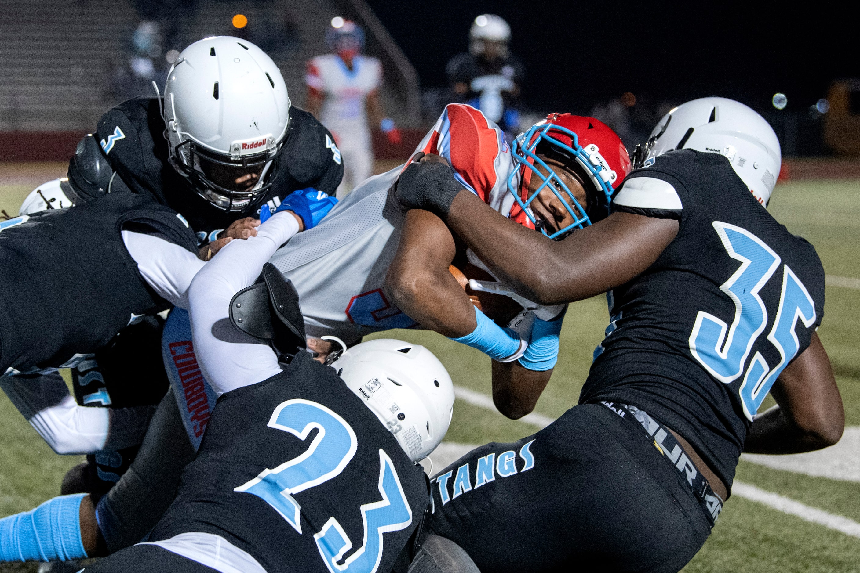 Carter junior wide receiver Datarian Borens (5) is brought down by Roosevelt defenders...