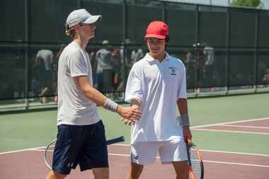 Highland Park's Cole Burnam (left) and Mikhail Commer (right) high-five in a double match...