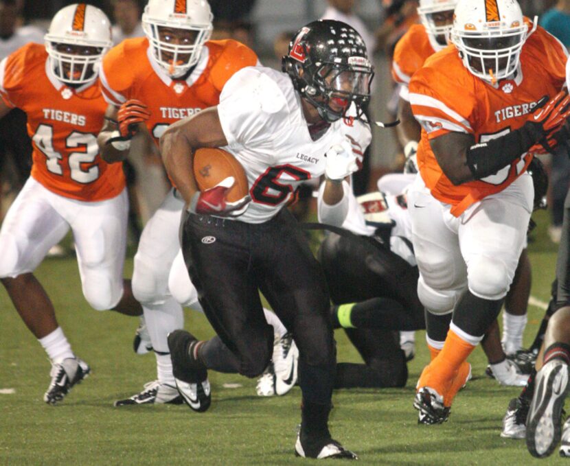 Mansfield Legacy junior running back Kijana Amous (6) is pursued by Lancaster defenders in...